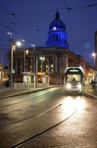 Nottingham Council House and Old Market Square in Nottingham at night, overlooked by the Council House, with trams running around the edge of the square