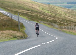 A cyclist descends Butter Tubs pass towards Swaledale